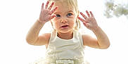 Nora a rejoint le concours — aidez-le/la à gagner de superbes lots ! blonde_hair, blue_eyes, braids, child, cute, dress, floral_background, flower, hands_up, innocent, playful, portrait, shoes, sitting, smiling, soft_light, studio_photo, toddler, white_dress, young_child