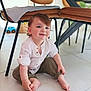 toddler, child, smiling, sitting, barefoot, white_shirt, olive_pants, rolled_cuffs, indoor, floor, tile, chair, table, toy_car, cute, happy, curly_hair, baby, person, home