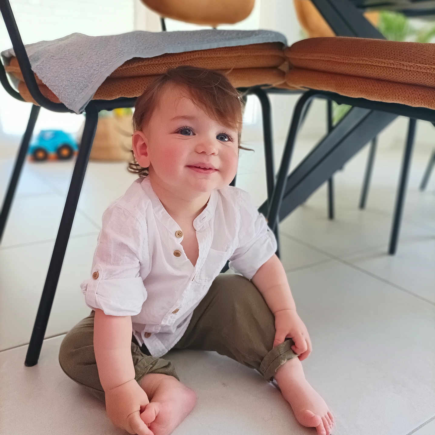 Andrea participe au concours pour gagner de l'argent avec cette photo : baby, barefoot, chair, child, curly_hair, cute, floor, happy, home, indoor, olive_pants, person, rolled_cuffs, sitting, smiling, table, tile, toddler, toy_car, white_shirt