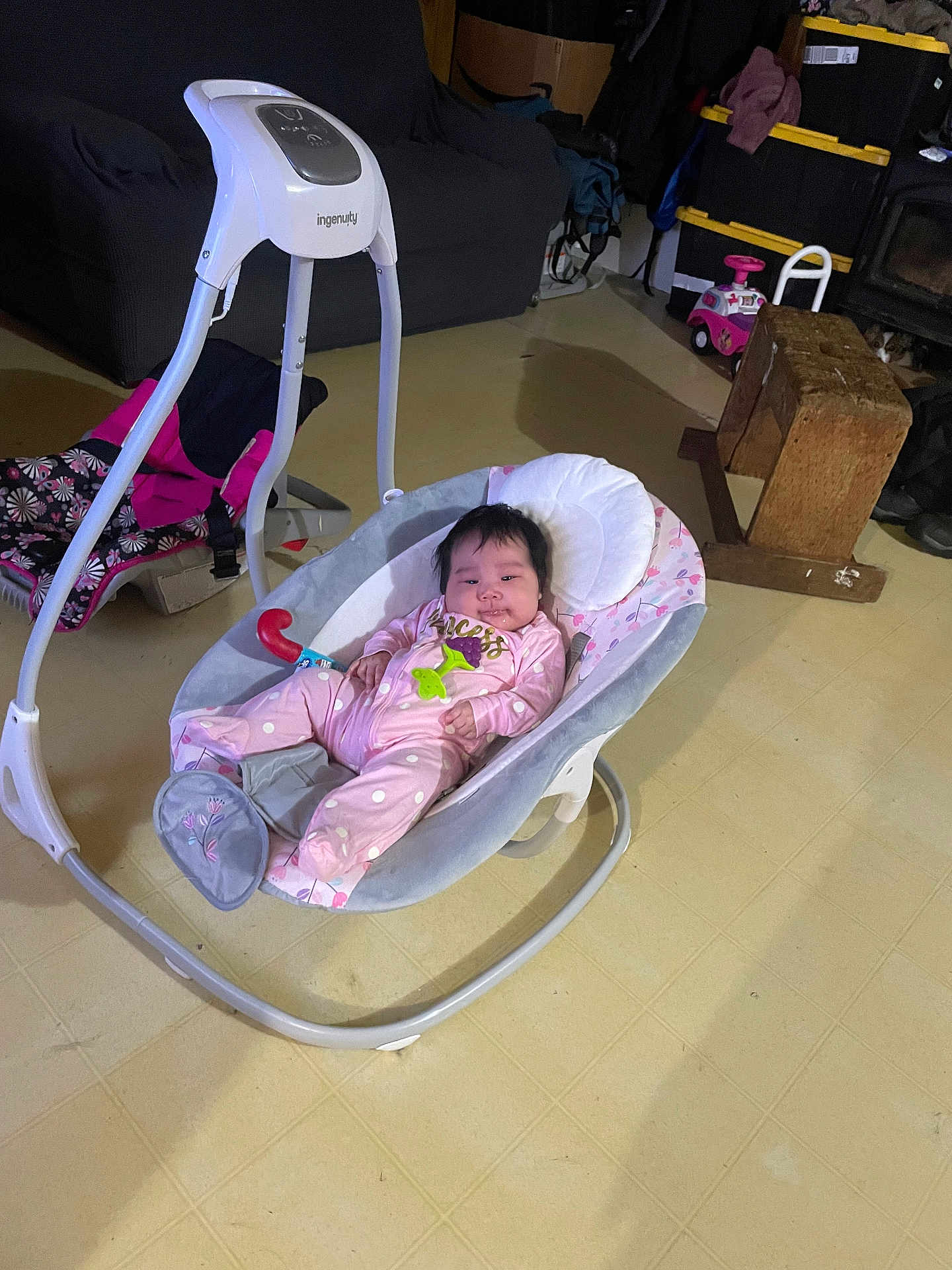 Genesis joined the competition — help win amazing prizes! baby, baby_swing, pink_clothing, indoor, floor, toy, couch, wooden_block, carpet, child, infant, person, face, household, plaything, flooring, smile, relaxing, furniture, room