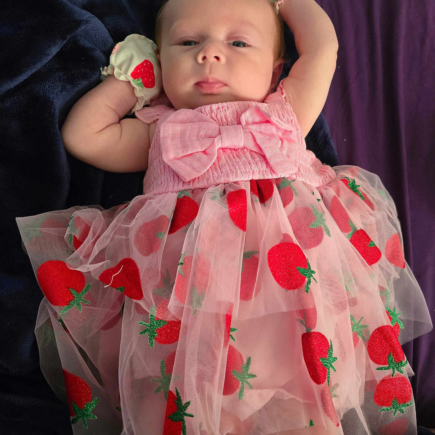 Terrilyn is registered to the contest to win money with this photo: baby, blanket, child, closeup, clothing, cute, face, indoors, infant, lying_down, mittens, newborn, person, pink_dress, portrait, relaxed, sleepwear, soft_fabric, strawberry_pattern, tulle