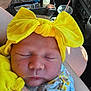Terrilyn is registered to the contest to win money with this photo: baby, newborn, yellow_bow, headband, sleeping, infant, car_interior, pacifier, clothing, arm, tattoo, closeup, peaceful, resting, floral_pattern, skin, child, person, cute, portrait