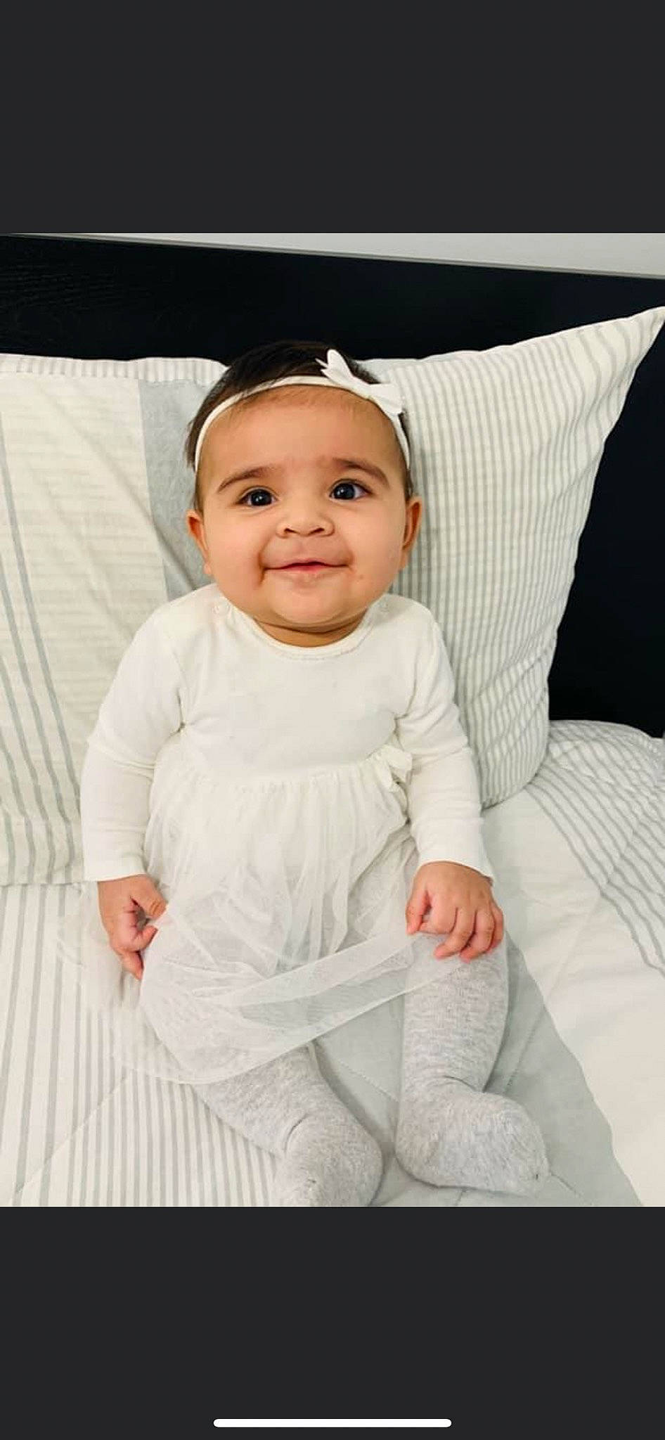 Aisha is registered to the contest to win money with this photo: arm, baby, baby_toddler_clothing, beauty, cheek, child, collar, comfort, grey, happy, joy, linens, neck, pattern, person, pink, product, sleeve, smile, t_shirt