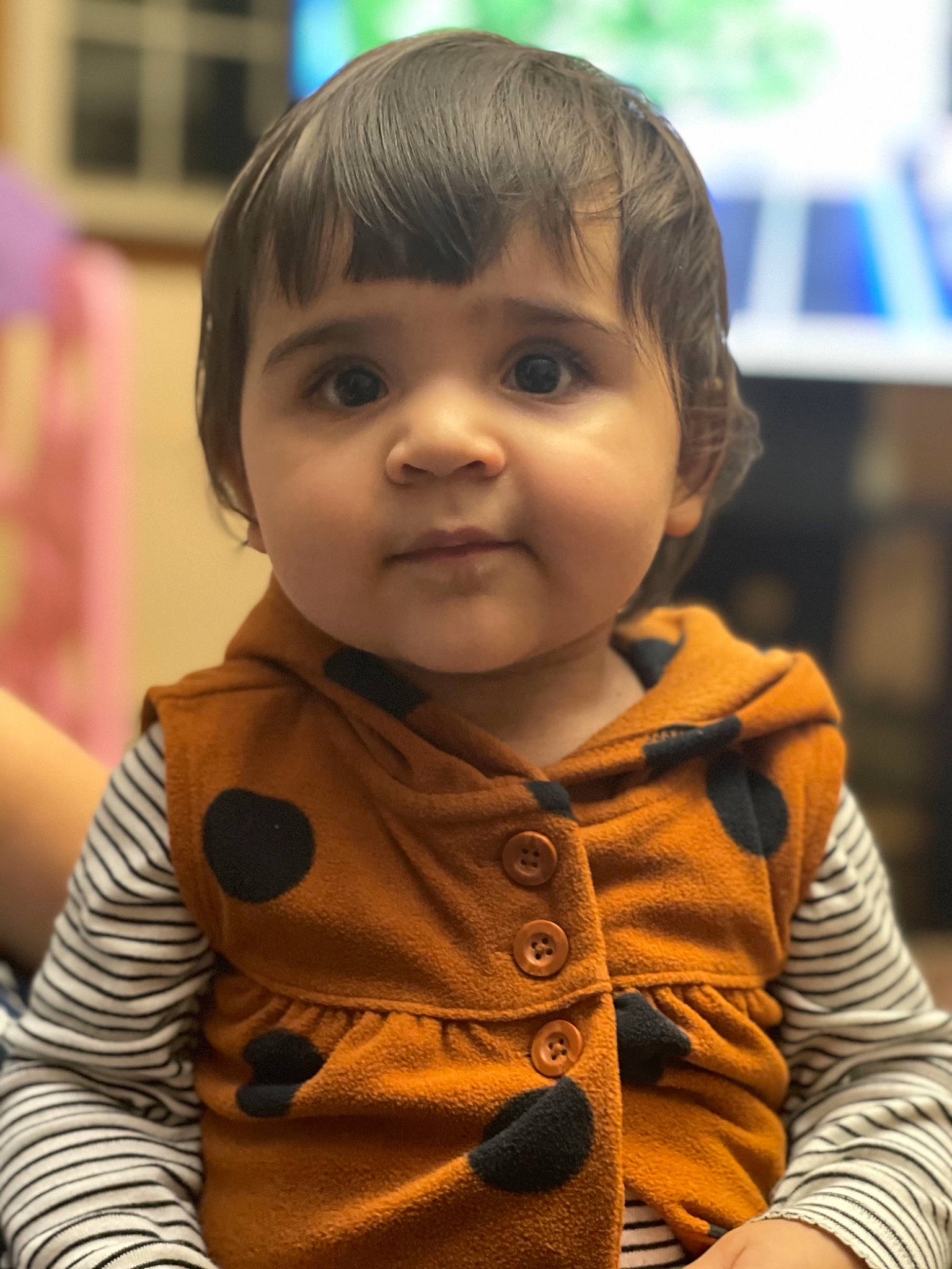 Aisha is registered to the contest to win money with this photo: baby, baby_toddler_clothing, button, cheek, child, chin, eyelash, fun, happy, iris, lip, nose, person, sitting, skin, sleeve, smile, t_shirt, television, toddler