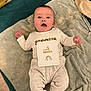 baby, infant, child, milestone_card, towel, bedding, onesie, pants, face, smiling, surprised, lying_down, indoor, blanket, rainbow, card, feet, hands, portrait, home