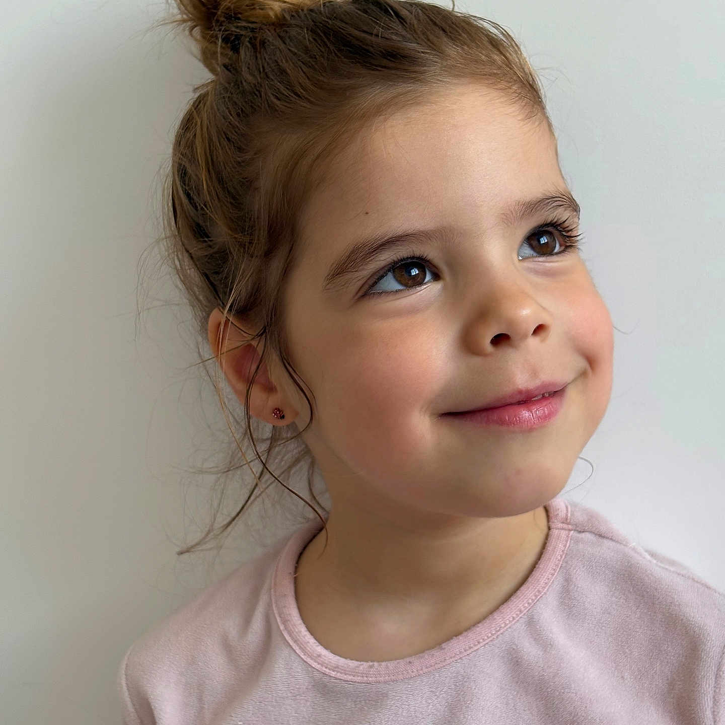 Giulia participe au concours pour gagner de l'argent avec cette photo : accessories, bodypart, bunhairstyle, child, clothing, face, female, girl, hair, happy, head, jewelry, neck, person, photography, ponytail, portrait, shoulder, smile, t_shirt