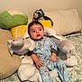 baby, infant, mickey_mouse, onesie, plush_toy, elephant_pillow, stuffed_animal, raccoon, cushion, bed, blanket, pajamas, child, indoor, soft_toys, cute, sleepwear, relaxed, person, young_child