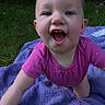 baby, child, smiling, pink_clothing, purple_blanket, outdoor, grass, greenery, happy, crawling, infant, person, face, tongue, cute, nature, tattoo, skin, head, eyes