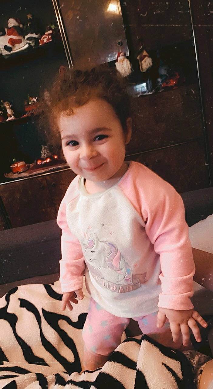 Giulia participe au concours pour gagner de l'argent avec cette photo : baby, baby_toddler_clothing, cheek, child, joy, laugh, long_sleeved_t_shirt, mouth, nightwear, person, sitting, sock, toddler