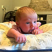 Levi joined the competition — help win amazing prizes! baby, infant, cushion, whale_pattern, hand, thumb, face, blue_eyes, pink_clothing, indoor, fan, background, wall, curious, closeup, skin, head, expression, soft_light, person