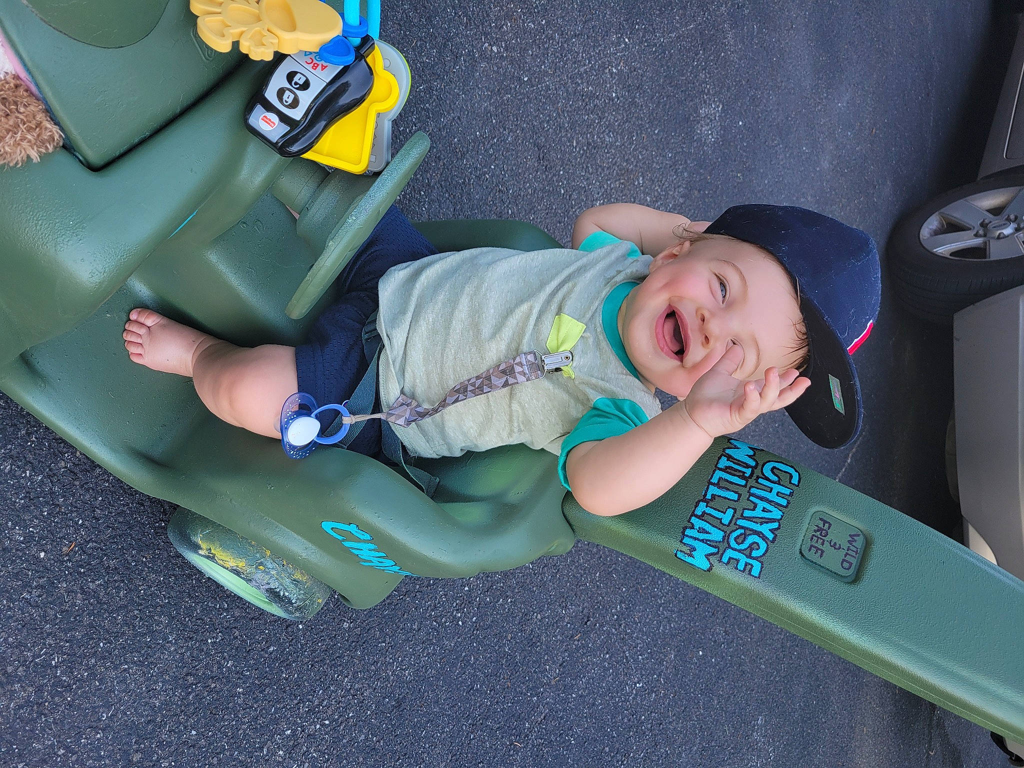 Chayse is registered to the contest to win money with this photo: auto_part, automotive_design, automotive_exterior, baby_toddler_clothing, bumper, car_seat, child, cool, electric_blue, family_car, fun, headwear, leg, motor_vehicle, person, personal_protective_equipment, smile, sneakers, toddler, trunk