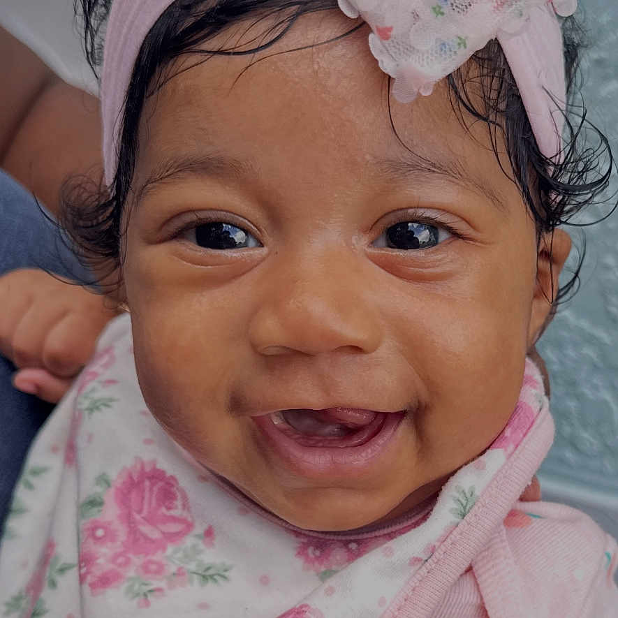 Isla Anani joined the competition — help win amazing prizes! baby, child, smiling, headband, bow, pink, floral, bib, clothing, face, portrait, happy, cute, person, infant, indoors, skin, eyes, hair, expression