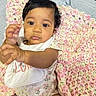 Isla Anani is registered to the contest to win money with this photo: baby, infant, child, blanket, crochet, plush_toy, bed, pillow, onesie, bib, cute, indoor, person, skin, hand, face, expression, sitting, young, cozy