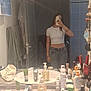 mirror, selfie, bathroom, person, crop_top, jeans, toiletries, sink, faucet, soap_dispenser, mirror_reflection, bracelets, necklace, phone, hand, door, towel, cabinet, countertop, hair_brush