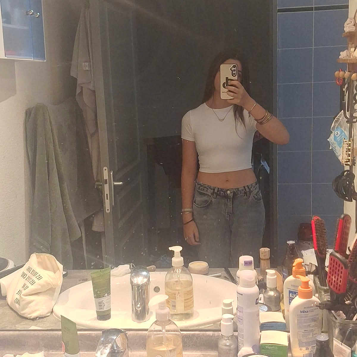 Elisounette participe au concours pour gagner de l'argent avec cette photo : bathroom, bracelets, cabinet, countertop, crop_top, door, faucet, hair_brush, hand, jeans, mirror, mirror_reflection, necklace, person, phone, selfie, sink, soap_dispenser, toiletries, towel