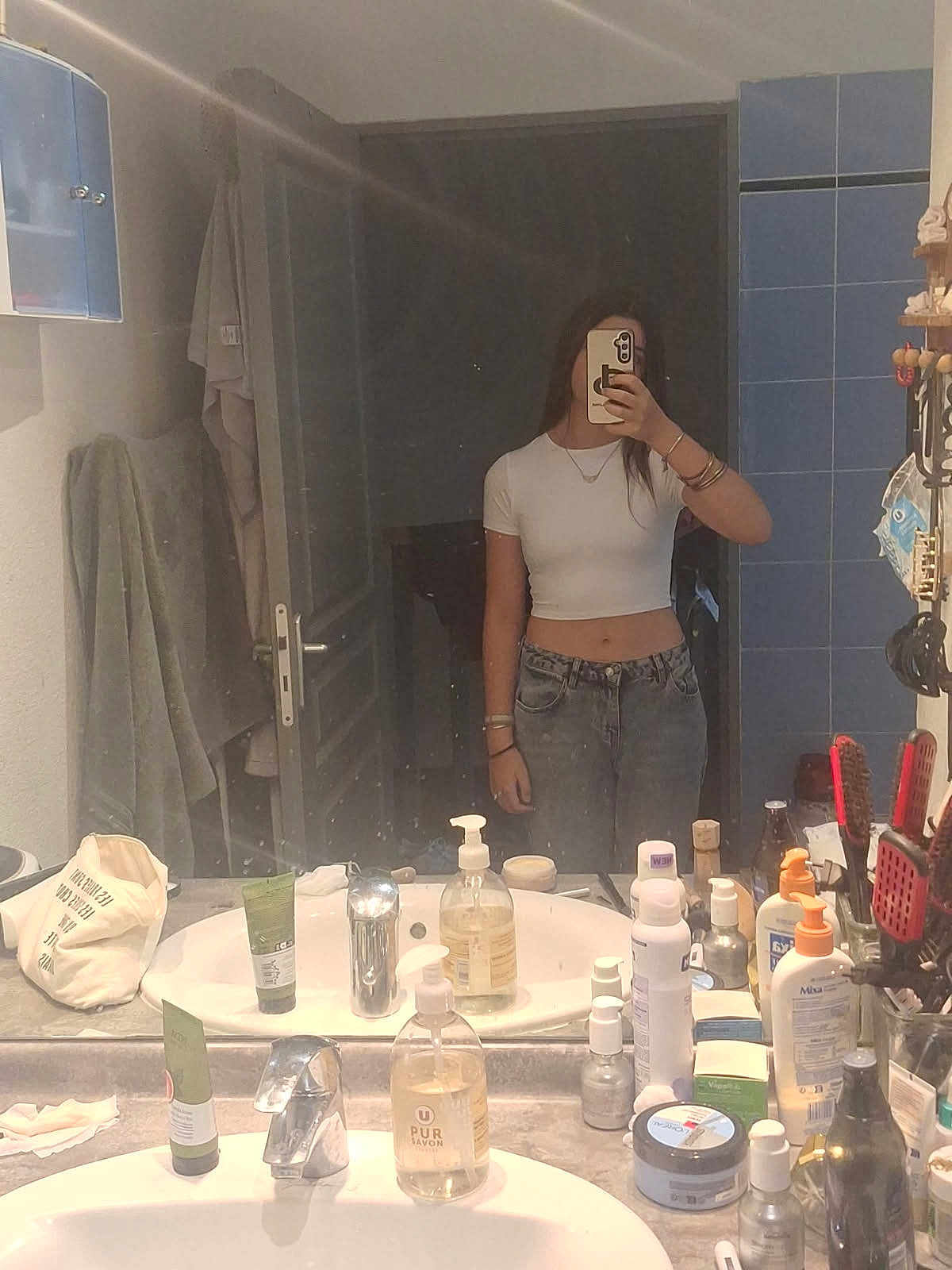 Elisounette participe au concours pour gagner de l'argent avec cette photo : mirror, selfie, bathroom, person, crop_top, jeans, toiletries, sink, faucet, soap_dispenser, mirror_reflection, bracelets, necklace, phone, hand, door, towel, cabinet, countertop, hair_brush