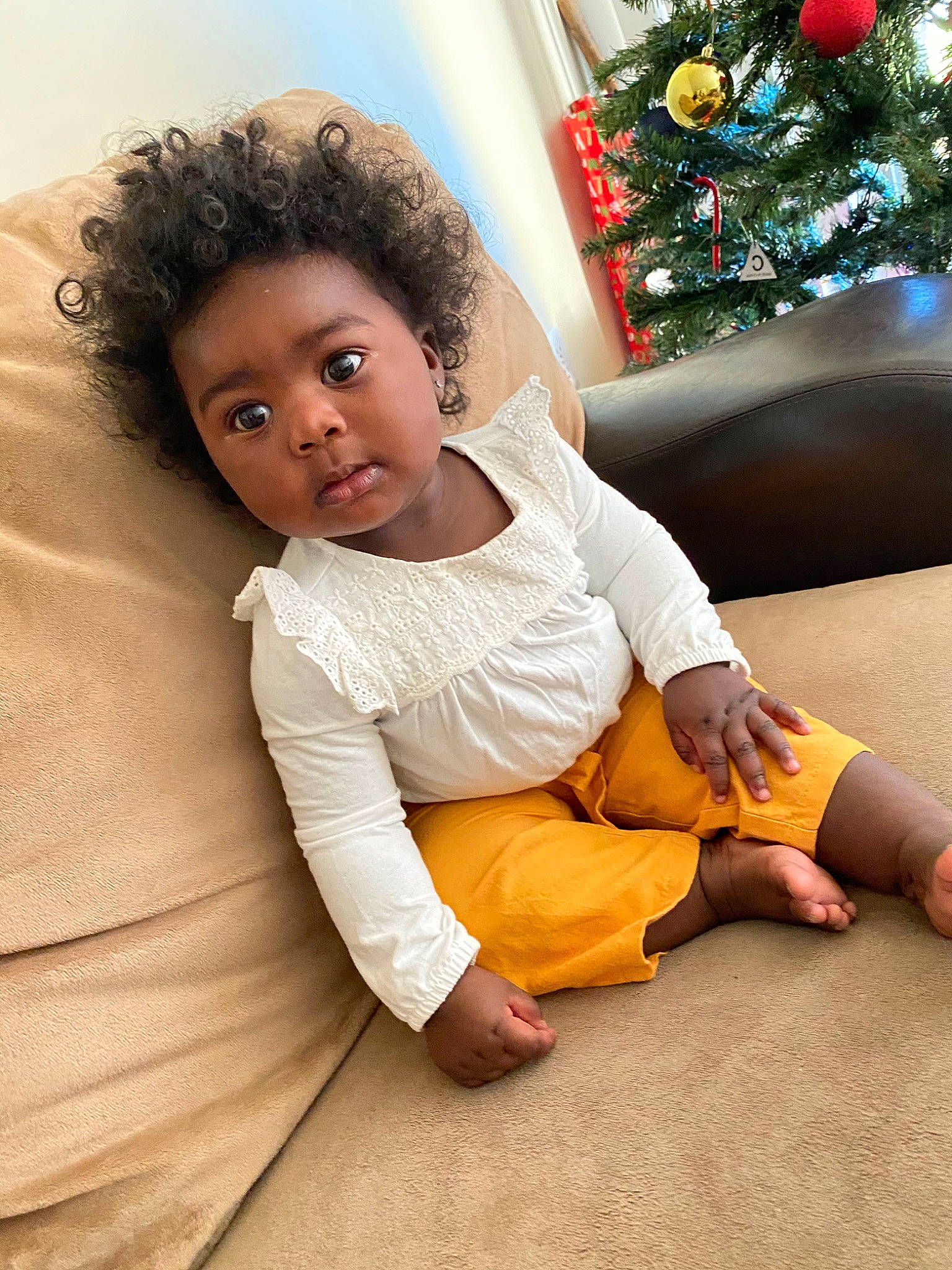 Jaelyn joined the competition — help win amazing prizes! arm, barefoot, child, christmas_decoration, christmas_tree, comfort, elbow, flash_photography, floor, flooring, foot, fun, happy, human_leg, knee, ornament, person, sitting, sleeve, thigh