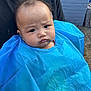 baby, child, blue_cape, face, furrowed_brow, person, black_shirt, outdoor, plastic, cape, head, expression, portrait, curious, young_child, human, skin, hair, reflection, background