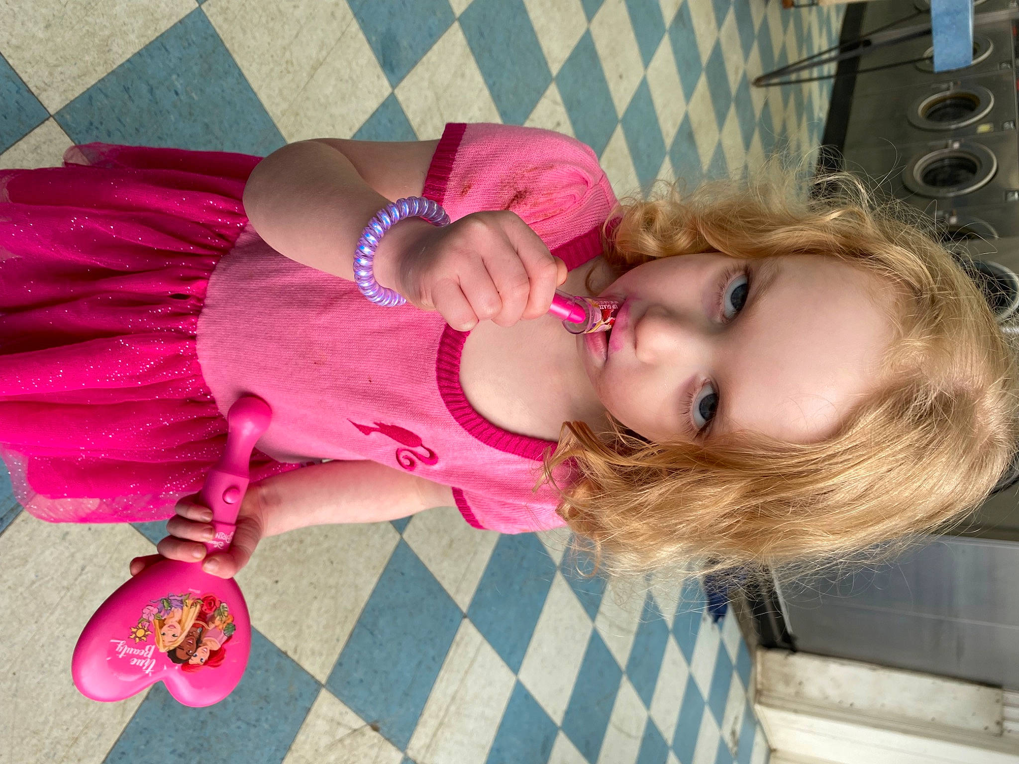 Elizabeth is registered to the contest to win money with this photo: baby, baby_toddler_clothing, cheek, child, dress, eyelash, facial_expression, fun, happy, human_leg, lip, magenta, pattern, person, pink, purple, sitting, skin, thigh, toddler