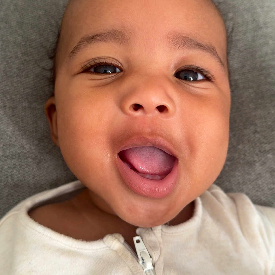 Amari-Jaicob joined the competition — help win amazing prizes! baby, child, close_up, cute, expression, eyes, face, happy, head, indoor, infant, mouth_open, person, portrait, skin, smiling, soft_texture, white_clothing, young, zipper