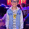 audience, badge, boy, child, competition, denim_jacket, event, fashion, glasses, hoodie, indoor, jeans, lighting, number, person, smile, stage, standing, striped_shirt, top_model_belgium