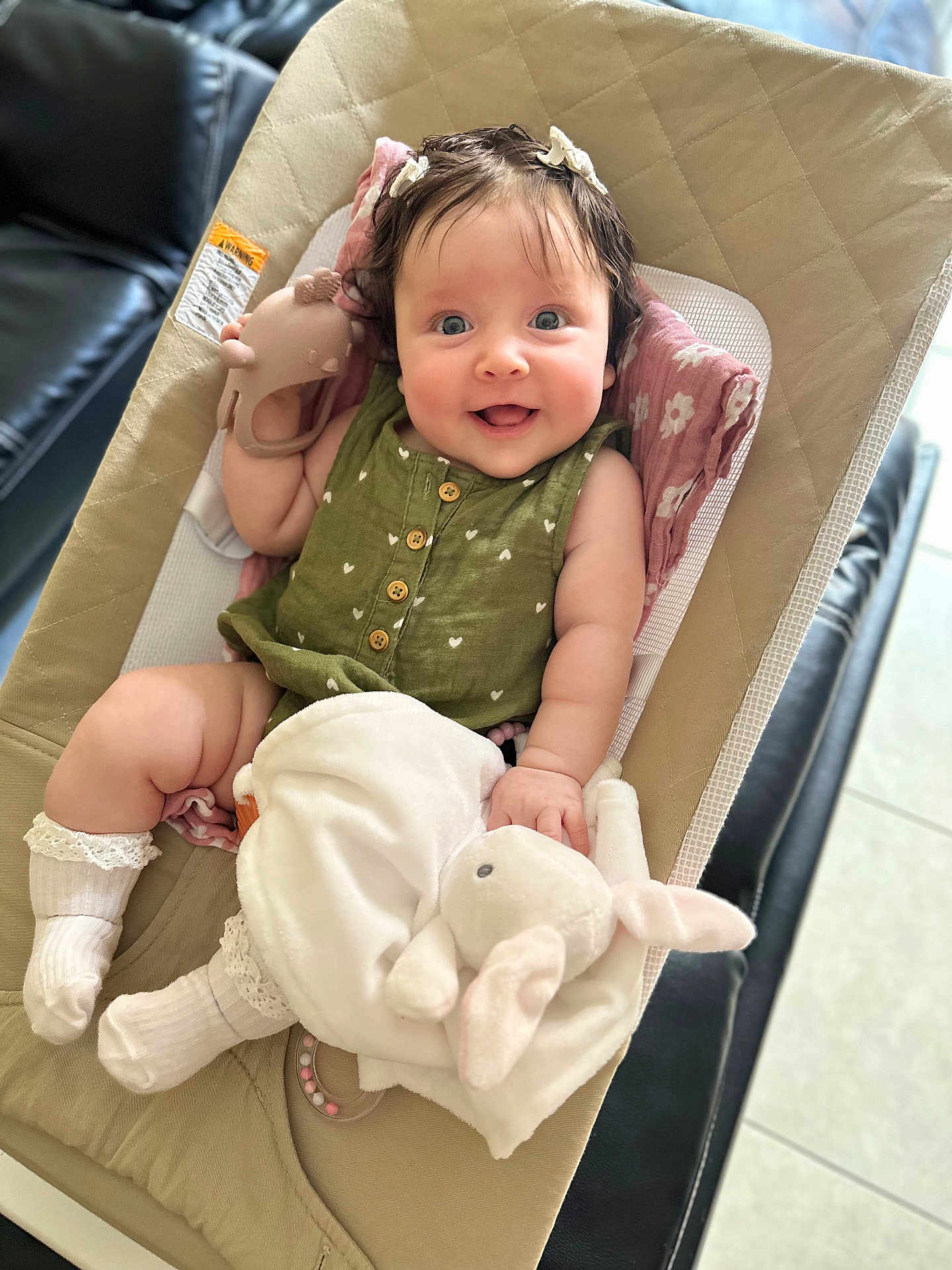 Mia joined the competition — help win amazing prizes! baby, infant, smiling, green_clothing, white_socks, plush_toy, bunny_toy, teether, baby_seat, blanket, indoor, happy, cute, child, person, portrait, soft_lighting, cushion, relaxed, playful
