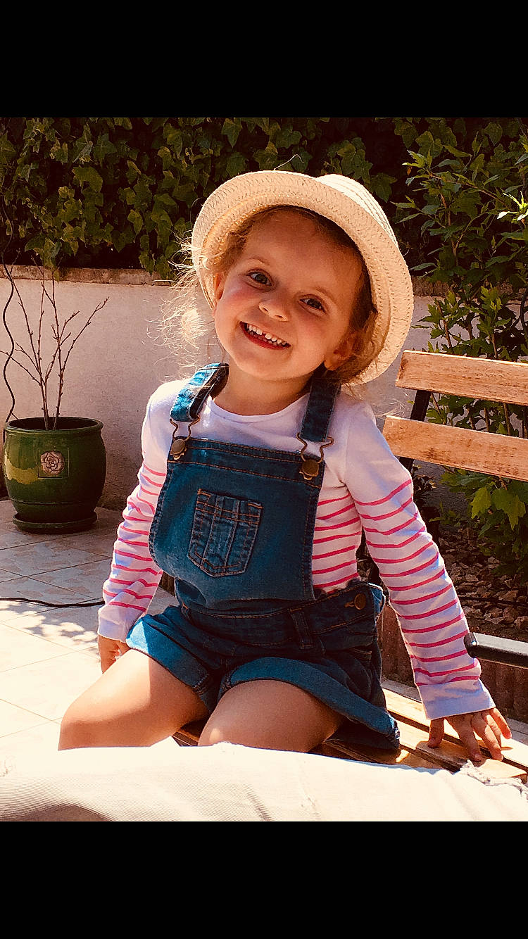 Ileana a rejoint le concours — aidez-le/la à gagner de superbes lots ! baby_toddler_clothing, cap, child, clothing, face, facial_expression, grass, happy, hat, houseplant, joy, leg, people_in_nature, person, pink, plant, product, skin, smile, sun_hat