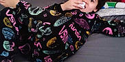 Noah is registered to the contest to win money with this photo: child, bed, blanket, clothing, curly_hair, face, furniture, indoor, looking_at_camera, nasa, person, pillow, plaid, pose, shirt, sleeve, toy, wall, young, youth