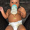 Asher joined the competition — help win amazing prizes! baby, bottle, diaper, necklace, milk, sitting, couch, child, person, indoors, cute, young, infant, skin, hand, face, expression, feeding, relaxing, clothing