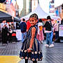 child, girl, smiling, dress, braided_hair, bracelet, urban, street, city, people, crowd, footwear, posing, fashion, daylight, side_view, outdoor, happy, background_blur, public_place