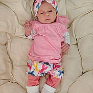 Naëlya participe au concours pour gagner de l'argent avec cette photo : baby, infant, pink_clothing, headband, blanket, white_socks, patterned_shorts, lying_down, indoors, soft_texture, cute, portrait, child, newborn, small_hands, footwear, sleepwear, fabric, resting, comfortable