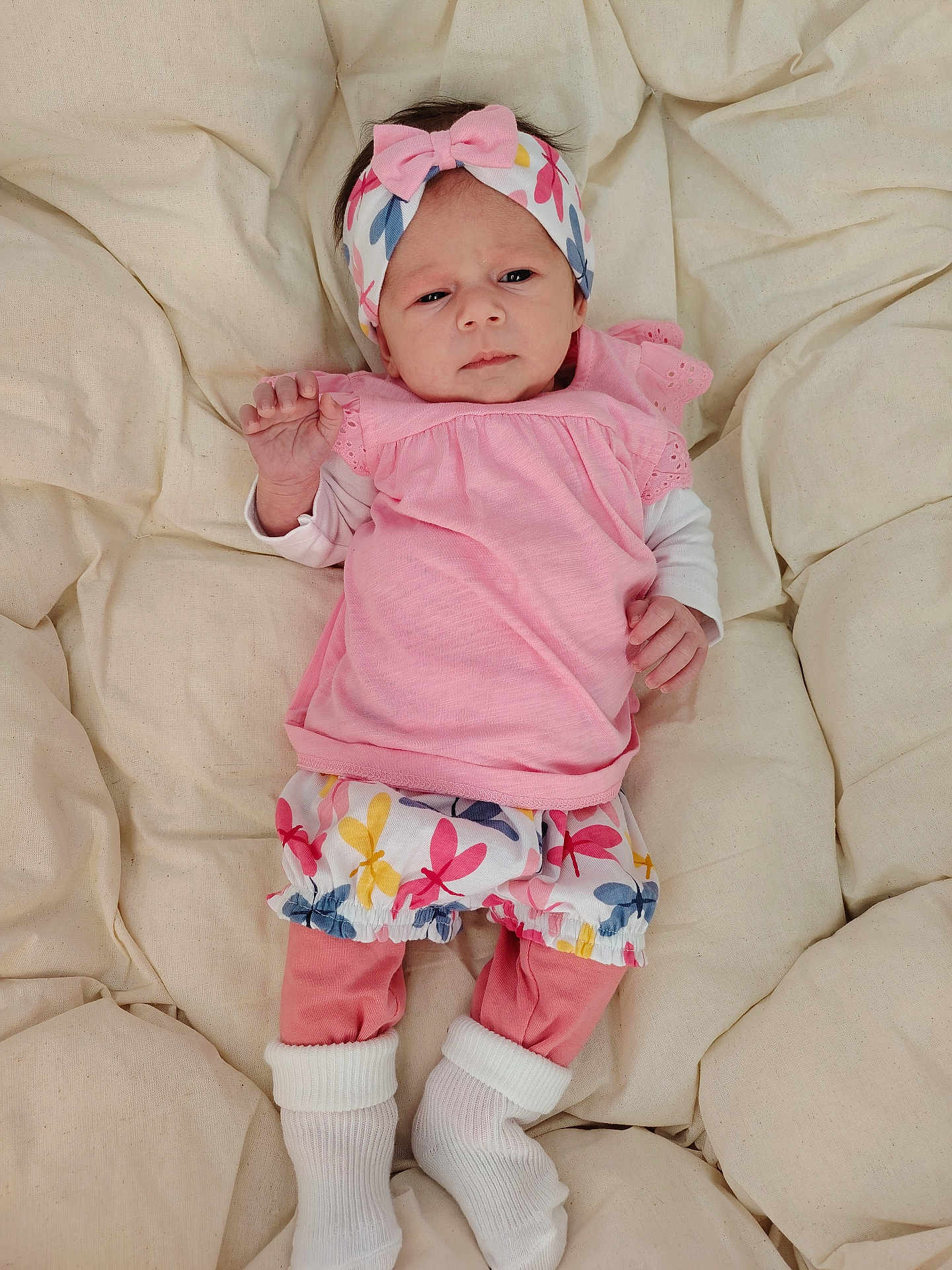 Naëlya participe au concours pour gagner de l'argent avec cette photo : baby, infant, pink_clothing, headband, blanket, white_socks, patterned_shorts, lying_down, indoors, soft_texture, cute, portrait, child, newborn, small_hands, footwear, sleepwear, fabric, resting, comfortable