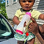 Amara joined the competition — help win amazing prizes! toddler, child, baby_bottle, pink_sandals, yellow_bow, curly_hair, outdoor, car, hand, keys, milk, shorts, person, sunlight, face, expression, summer, clothing, skin, holding