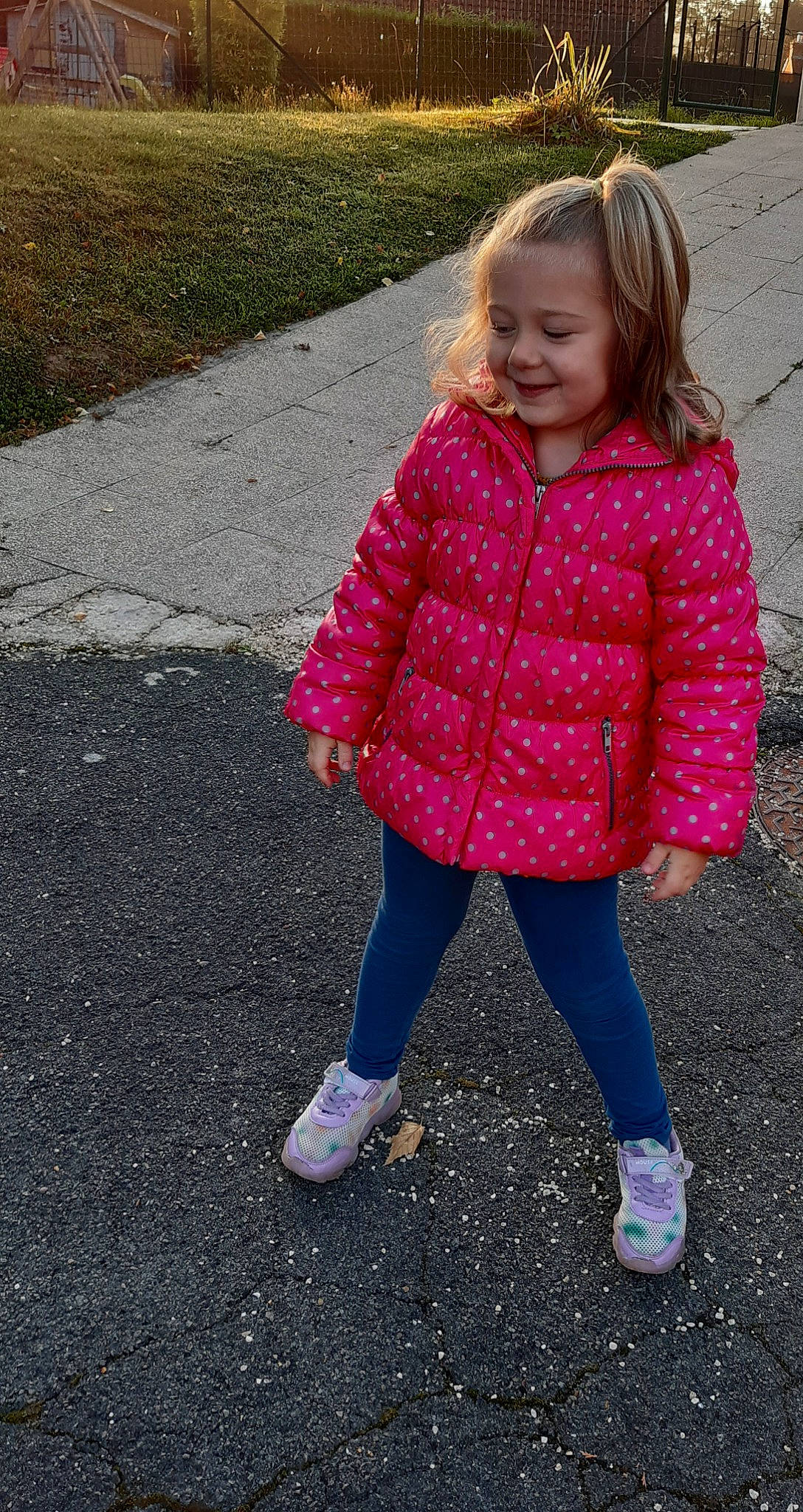 Anaïs participe au concours pour gagner de l'argent avec cette photo : asphalt, baby_toddler_clothing, dress, eye, face, footwear, grass, hair, happy, head, jacket, joy, outerwear, pattern, person, plant, recreation, road_surface, sleeve, smile