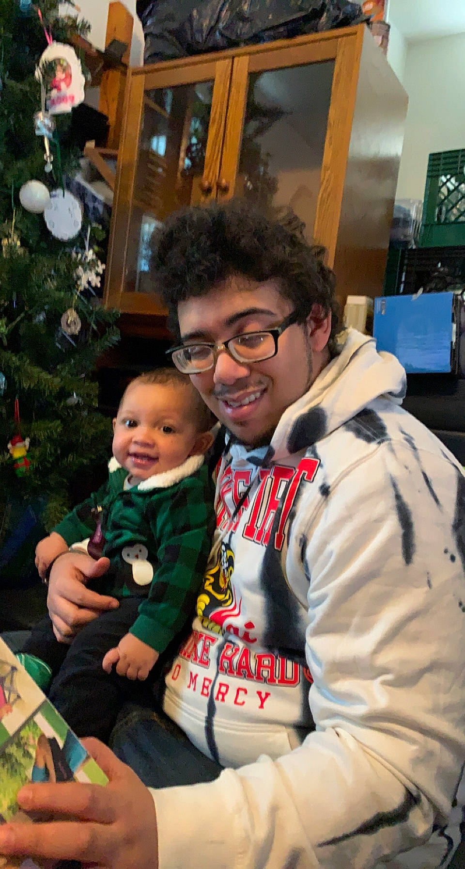 Oliver is registered to the contest to win money with this photo: baby, child, christmas_decoration, christmas_ornament, christmas_tree, conifer, event, eyewear, fun, fur, glasses, happy, holiday, holiday_ornament, joy, lap, ornament, person, smile, toddler