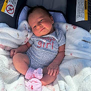Scarlett is registered to the contest to win money with this photo: baby, infant, child, car_seat, blanket, onesie, pink_socks, smile, face, cute, cozy, soft, indoors, clothing, newborn, resting, comfort, happy, portrait, baby_girl