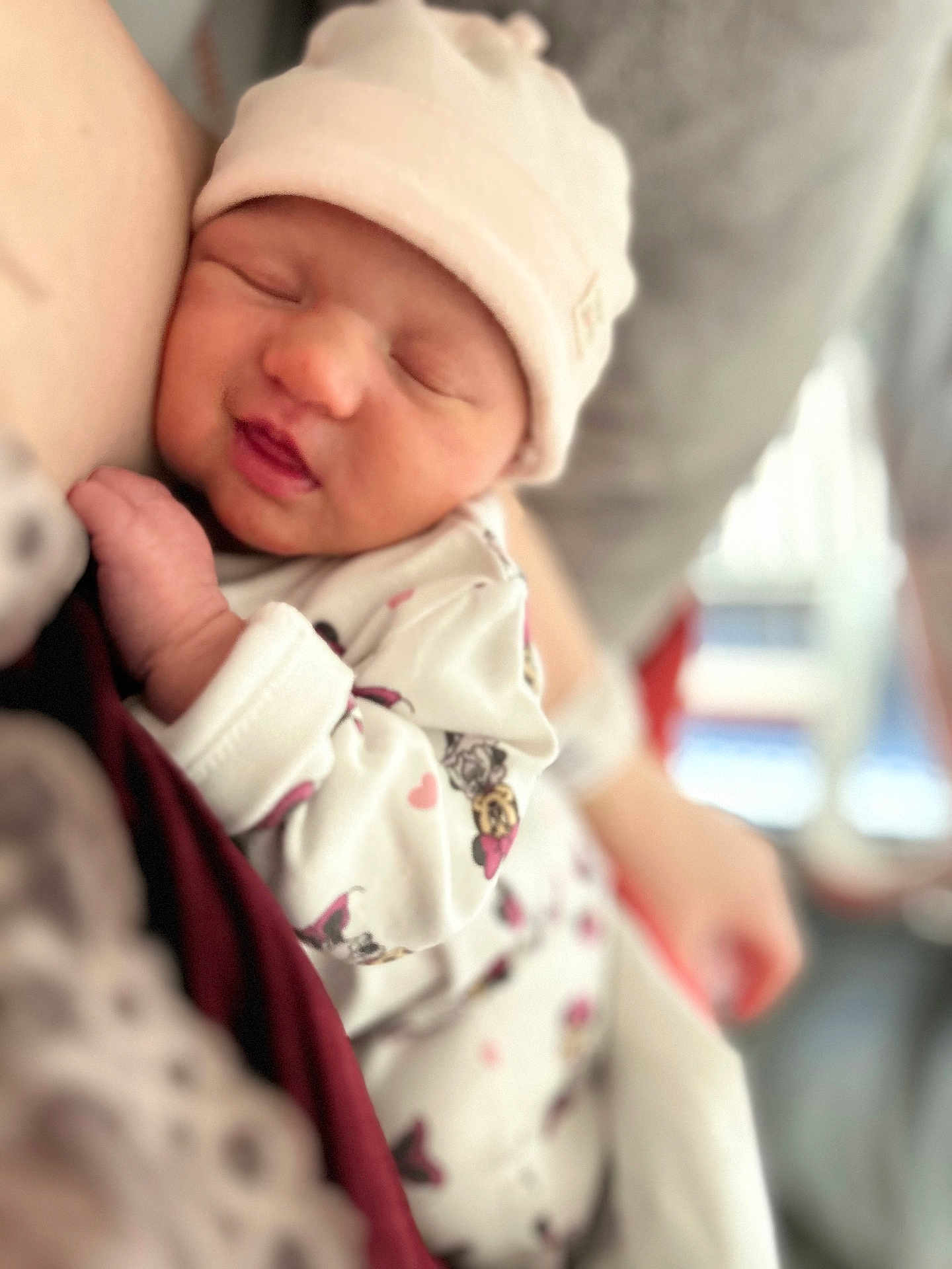 Liyana participe au concours pour gagner de l'argent avec cette photo : baby, newborn, infant, sleeping, hat, onesie, cartoon_print, cute, cozy, snuggling, person, arm, soft_focus, indoor, portrait, closeup, child, face, peaceful, warm