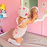 Melanie joined the competition — help win amazing prizes! toddler, child, mirror, reflection, pink_wall, knit_clothing, bonnet, changing_table, plush_doll, playful, smiling, indoor, cute, baby, room_decor, wall_art, kneeled, white_socks, pastel_colors, happy