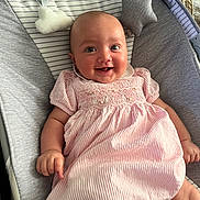 Rosa joined the competition — help win amazing prizes! baby, infant, smiling, dress, pink, striped, baby_rocker, cushion, soft_toys, face, happy, child, person, indoor, cute, comfort, relaxing, young, portrait, clothing
