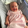 baby, infant, smiling, dress, pink, striped, baby_rocker, cushion, soft_toys, face, happy, child, person, indoor, cute, comfort, relaxing, young, portrait, clothing