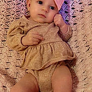 Ellie joined the competition — help win amazing prizes! baby, infant, pink_bow, headband, blanket, knit, clothing, cute, portrait, child, soft_texture, laying_down, skin, legs, hands, face, expression, indoor, young, adorable