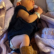 Ellie joined the competition — help win amazing prizes! baby, sleeping, blanket, headband, boots, clothing, infant, diaper, hand, face, person, soft_texture, purple, white, navy_blue, hospital_bracelet, cute, resting, newborn, cozy