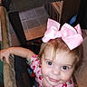 Rosalie joined the competition — help win amazing prizes! toddler, child, pink_bow, playpen, indoor, curious, smile, face, person, clothing, patterned_shirt, hair, baby, young_child, hand, light, home, cute, portrait, looking_up