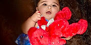 Audrey is registered to the contest to win money with this photo: baby, blue_dress, bow, child, closeup, cute, face, fuzzy_background, hand, happy, holding, indoor, infant, person, plush_toy, portrait, red_bear, smiling, soft_toy, young_child