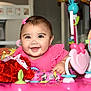 activity_center, baby, bow, cheerful, child, closeup, colorful, cute, decor, face, happy, indoor, infant, person, pink_clothing, plastic, play, smiling, toy, young_child