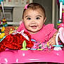 baby, child, pink_clothing, smiling, happy, toy, plush_toy, activity_center, indoor, face, infant, cute, play, colorful, ribbon, bright, person, young_child, adorable, expression