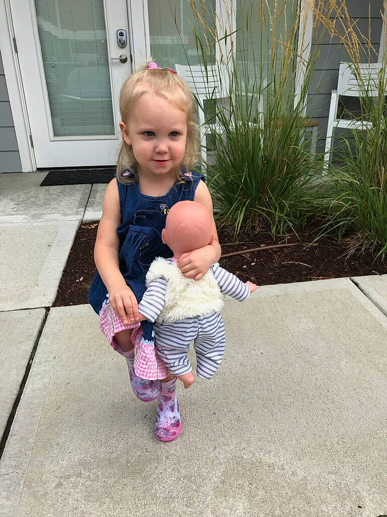 Remi is registered to the contest to win money with this photo: asphalt, baby, baby_toddler_clothing, child, door, eye, facial_expression, foot, fun, gesture, grass, happy, head, leisure, person, plant, road_surface, sandal, skin, thumb