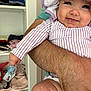 baby, infant, smile, striped_clothing, hat, arm, adult, holding, shelf, clothes, baby_supplies, diapers, indoor, happy, cute, person, skin, flesh, close_up, portrait