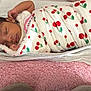 newborn, baby, sleeping, blanket, cherry_pattern, swaddled, soft_bedding, pink, white, peaceful, infant, cute, resting, indoors, child, portrait, cozy, wrapped, toddler, face