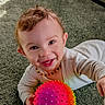baby, ball, carpet, child, clothing, colorful, crawling, cute, face, happy, home, indoor, necklace, person, playful, smiling, spiky_ball, toddler, toy, young_child